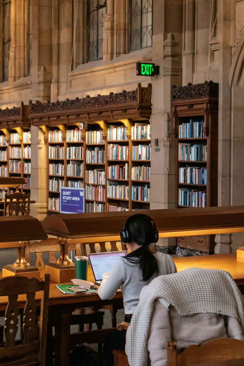 Studentkinja uči sa laptopom u univerzitetskoj biblioteci